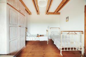 ゴンスキにあるSPOKÓJ & DOBRO - slow life apartmentsの白い壁とウッドフロアの客室で、ベッド2台が備わります。