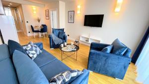 巴统Apartments Black Sea Resort的带蓝色沙发和电视的客厅