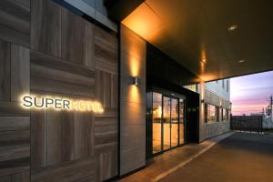 a sign on the side of a super hotel building at Super Hotel Shikoku-chuo in Shikokuchuo