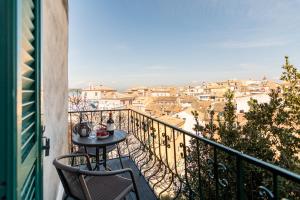 a table and chairs on a balcony with a view at Tenedos old town in Agios Rokkos