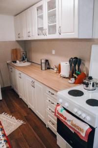 una cocina con armarios blancos y un horno de fogón blanco en Villa Katharina, en Kakanj