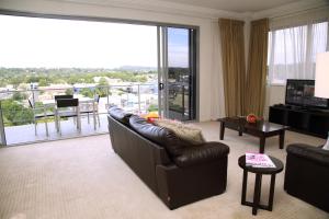 トゥーンバにあるToowoomba Central Plaza Apartment Hotel Officialのリビングルーム(革張りのソファ、バルコニー付)