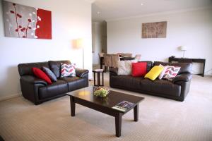 a living room with two couches and a coffee table at Toowoomba Central Plaza Apartment Hotel Official in Toowoomba