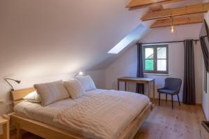 a bedroom with a bed and a desk and a window at Villa Richterberg with Sauna & Hot Tub in Slovenj Gradec