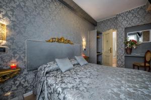 a bedroom with a large bed with blue wallpaper at Hotel Apostoli Garden in Venice