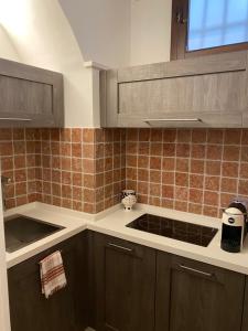 a kitchen with brown cabinets and a stove top at Piervì Suite in Putignano +28 photos