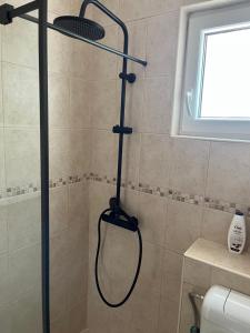 a shower with a black shower head in a bathroom at Jadran Studio in Budva