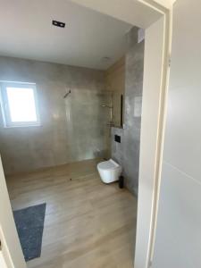 baño con aseo y ventana en Apartament Daleszyce en Daleszyce