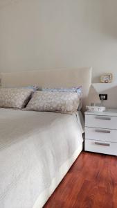 um quarto com uma cama branca e uma mesa de cabeceira em La Spezia La Perla dei Poeti em Vezzano Ligure