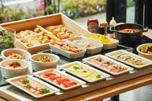 un buffet de diferentes tipos de comida en una mesa en ICI HOTEL Asakusabashi, en Tokio