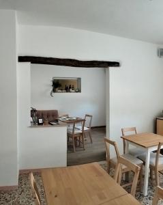 comedor con paredes blancas y mesas y sillas de madera en Agriturismo Le Crede 1930, en Portogruaro