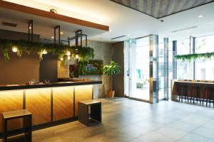 a restaurant lobby with a bar with plants at ICI HOTEL Ueno Shin Okachimachi in Tokyo