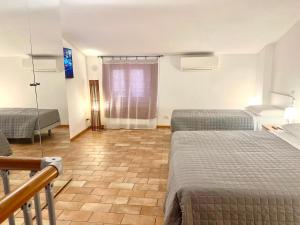 a hotel room with two beds and a window at GH Paradiso - Apartments in Siena