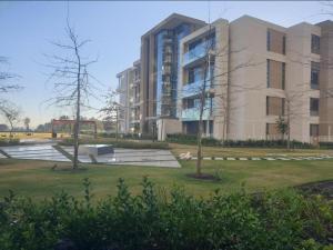 a large building with a park in front of it at Menlyn Maine Apartments in Pretoria
