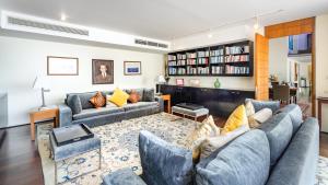 a living room with two couches and a book shelf at Villa Rom Trai in Kathu