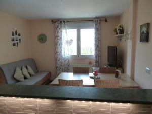 a living room with a table and a couch at Casita Melanie in Alhaurín el Grande
