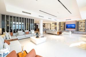 un grand salon avec des canapés et une télévision dans l'établissement Luxury Villa 8 bedroom with Sea and Mountain View with infinity pool, à Fujaïrah