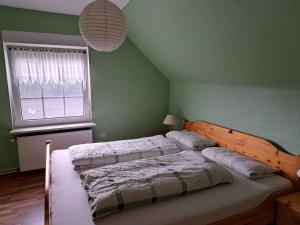 2 Betten in einem Schlafzimmer mit grünen Wänden in der Unterkunft Gästehaus "Ruth" in Neugaude