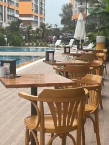 een rij tafels en stoelen naast een zwembad bij 2 bedroom in an sexy compound with Balcony in Antalya