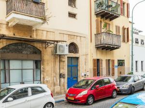 a group of cars parked in front of a building at Cozy Studio in Old Town in Tel Aviv