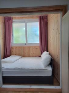 潭陽的住宿－JNW MINBAK，窗户客房内的小床
