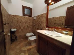 a bathroom with a sink and a toilet and a mirror at SanVitoTour- Residence Il Baglio in San Vito lo Capo