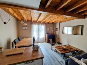 ein Wohnzimmer mit einem Holztisch und einer Couch in der Unterkunft ZAGALA LA MAISON DE LA MONTAGNE in Gèdre