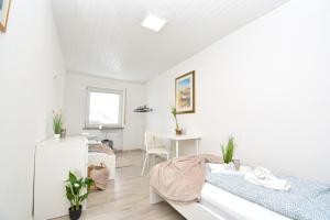 コー​​ブルクにあるCO02-HI Apartment in Coburgの白いベッドルーム(ベッド2台、デスク付)