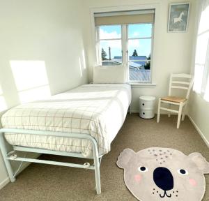 una camera da letto con un letto e un tappeto di orsacchiotto di Alta House ad Auckland