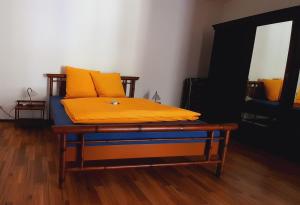 a bed with yellow pillows on it in a room at Cafe Hotel Aroma Moselblick in Burgen