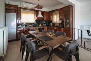 a kitchen with a wooden dining table and chairs at NisoVillas in Volos