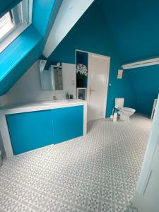 La salle de bains bleue est pourvue d'un lavabo et de toilettes. dans l'établissement Maison de Montgibaud, à Montgibaud