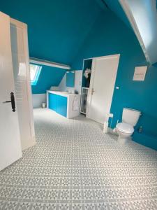La salle de bains bleue est pourvue de toilettes et d'un lavabo. dans l'établissement Maison de Montgibaud, à Montgibaud