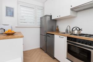 eine Küche mit Küchengeräten aus Edelstahl und einer Theke in der Unterkunft Cosy Apartment for 5 Guests Gdańsk Wrzeszcz by Renters in Danzig