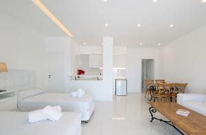Camera bianca con 2 letti e un tavolo di Aeri Villas & Apartments a Tourlos