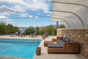 a patio with a swimming pool and chairs next to a building at NisoVillas in Volos