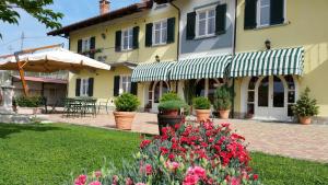 a house with flowers in front of a yard at Agriturismo Cascina Rabalot in Diano dʼAlba