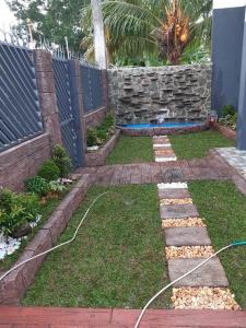 un jardin avec un tuyau fixé à l'herbe dans l'établissement CCJ Villa, à Bacolod