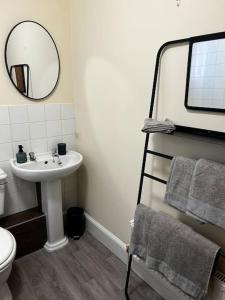 a bathroom with a sink and a mirror at Bright, spacious flat close to beach, Cliff Road in Sheringham +9 photos