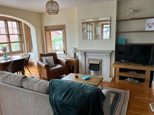 a living room with a couch and a fireplace at Bright, spacious flat close to beach, Cliff Road in Sheringham