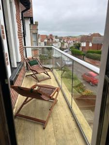 two chairs on a balcony with a view of a street at Flat 2, Cliff Road in Sheringham
