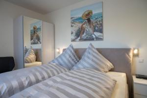 a bedroom with a bed and a picture of a woman at Fewo Schröder - Tolle in Norderney