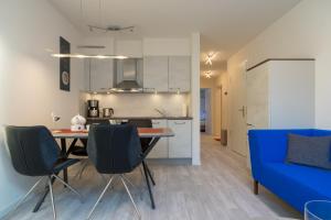 a kitchen and a dining room with a blue couch at Fewo Schröder - Tolle in Norderney