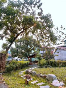 a tree in the middle of a garden with rocks at TokuGawa Hotel in Shuili