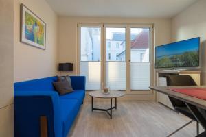 a living room with a blue couch and a table at Fewo Schröder - Tolle in Norderney