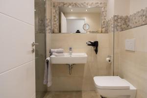 a bathroom with a sink and a toilet and a mirror at Fewo Schröder - Tolle in Norderney