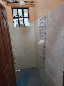 La salle de bains est pourvue d'une douche et d'une fenêtre. dans l'établissement G&G Homes Naka Nakuru, à Nakuru