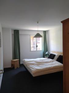 a bedroom with a large bed with green curtains at Haus Rovina in Münster