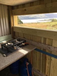 a kitchen with a stove and a window at sterlochy dome in Lochcarron