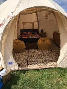 a tent with two chairs and a bed in it at sterlochy dome in Lochcarron